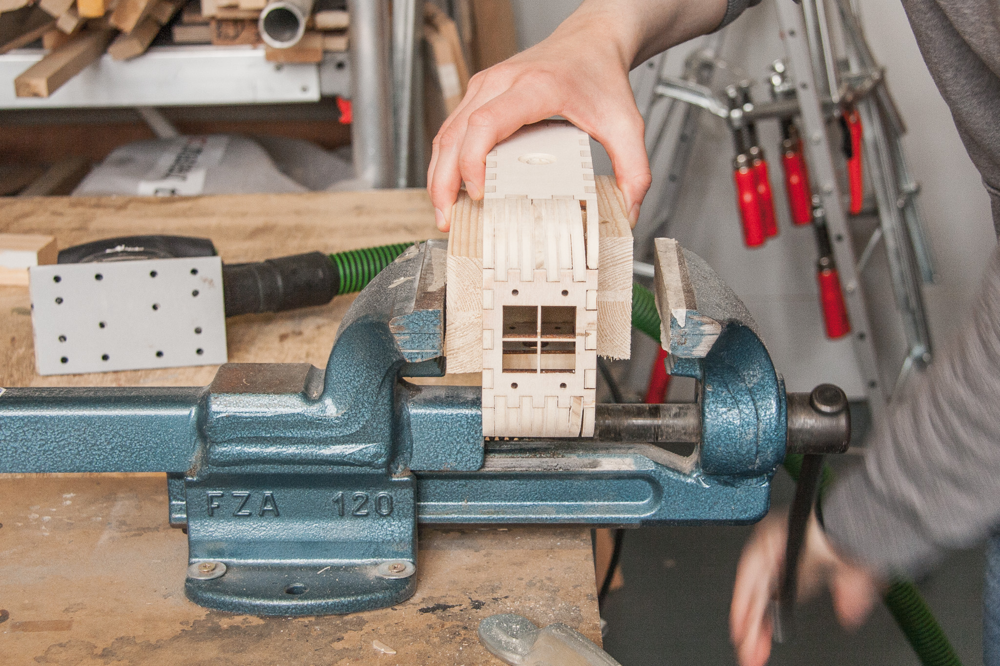 Fix the box in a vise with wooden blocks to protect it from dents.