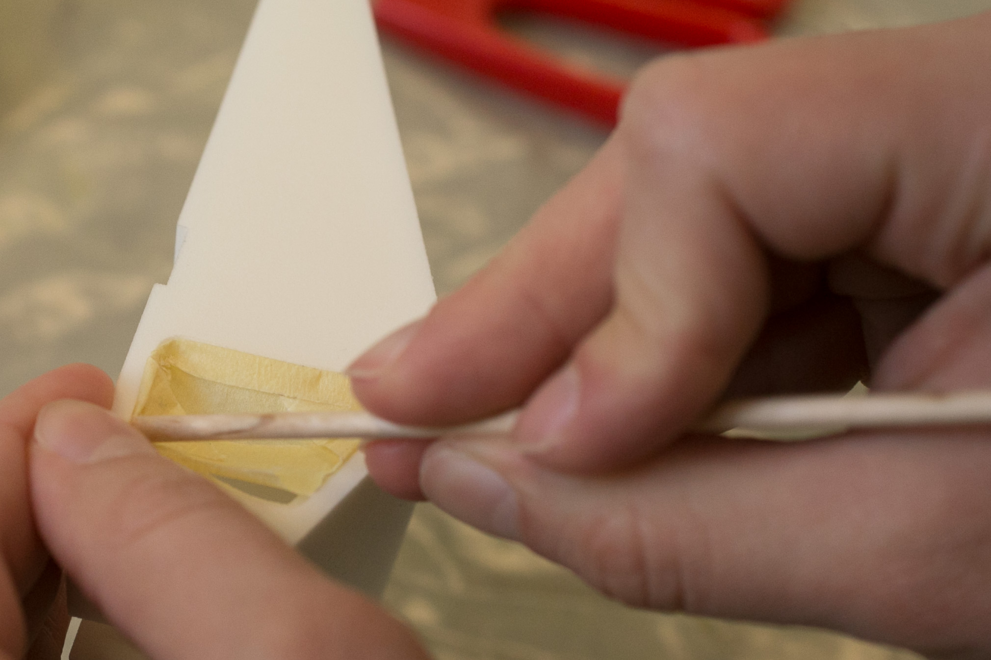 A pointy wooden stick helps when applying tape to tricky areas